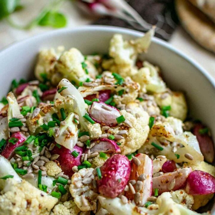 close up of balsamic roasted cauliflower and radishes sprinkled with chives.