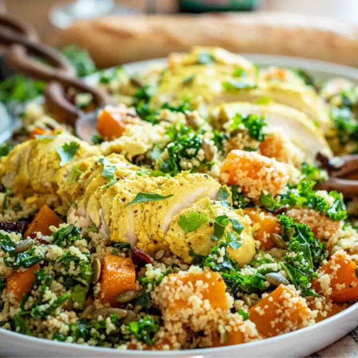 Post image featuring two sliced turmeric chicken breasts on top of a couscous kale salad.