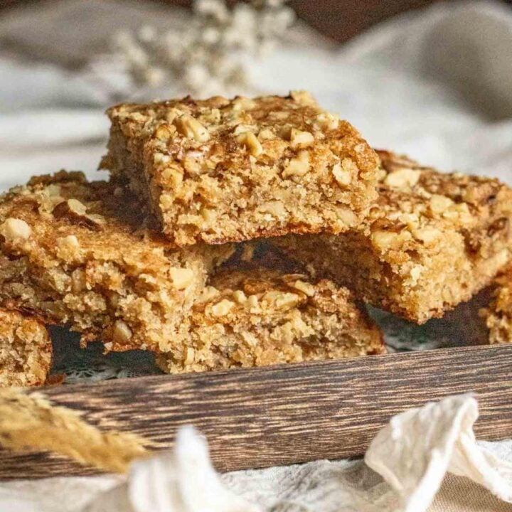 banana nut blondies stacked on a wooden tray.