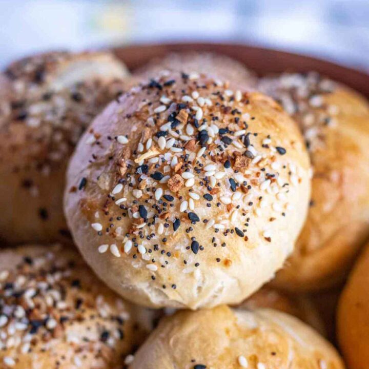Close up of a bagel bite sitting on top of more bagel bites.