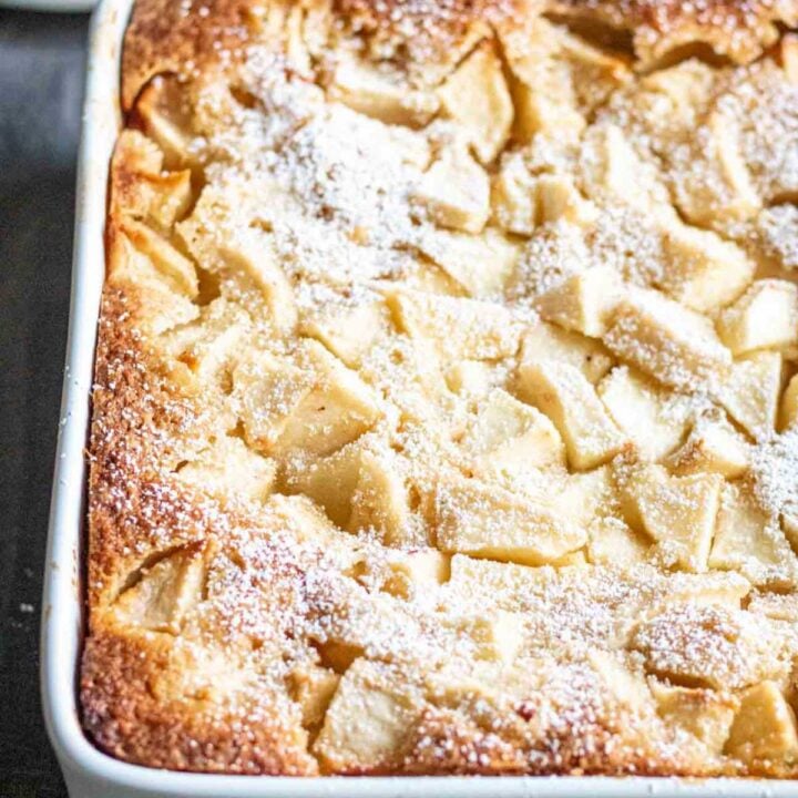 Angled shot of an apple snack cake, garnished with powdered sugar.