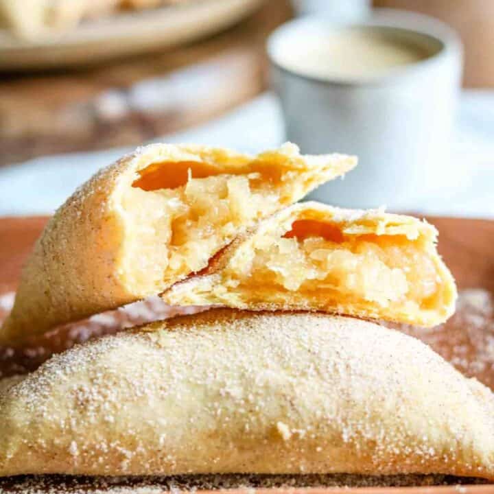 A pineapple empanada broken in half so you can see the pineapple filling and texture of the empanada dough.